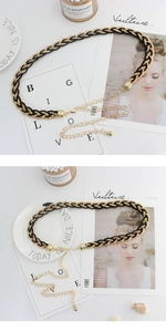 Detail of woven black and gold belt with metal extension chain and lobster clasp
