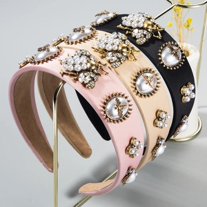 Detail of baroque headbands with pearls, rhinestones and golden bees on display