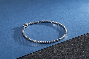 Detailed view of silver stainless steel box chain bracelet with lobster clasp closure