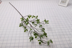 Detailed view of artificial Milan leaves on a brown branch against a grid background