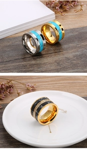 Detailed view of wide stainless steel rings with turquoise inlay and crystal accents