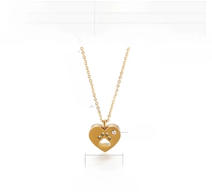 Detail view of a gold stainless steel heart pendant necklace with a zircon-set paw print