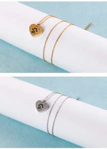 Detail of heart-shaped paw print necklaces in gold and silver finish with rhinestone