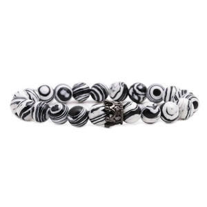 Macro view of white zebra jasper stone beads with a gun black zircon crown charm