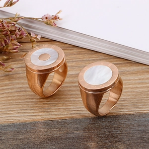 Rose gold stainless steel shell ring with Roman numerals on a wooden surface