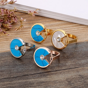 Rose gold and silver shell rings with turquoise inlay on a rustic wooden background