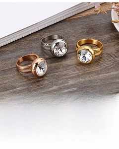 Detailed view of three circular cubic zirconia rings in gold, silver, and rose gold finishes