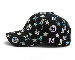 Detail of the black baseball cap showing blue-purple gradient M and star prints
