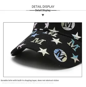 Macro detail of black cotton twill baseball cap with glossy star and letter M print