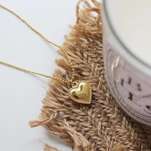 Detailed macro view of 18K gold-plated heart pendant with beaded edges and fine ball chain