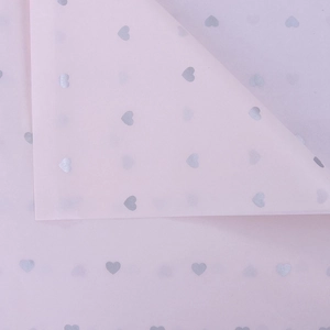 Detailed view of pink tissue paper with silver heart patterns for flower wrapping
