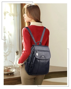 Close-up of black leather backpack featuring a metallic kangaroo logo and zip pocket