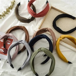 Flat lay of colorful handmade knotted fabric headbands in various solid colors