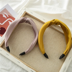 Detail of pink and yellow knotted fabric headbands with non-slip ends on white background