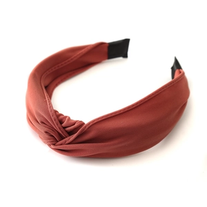 Brick red knotted wide headband made of premium knit fabric on a clean white background