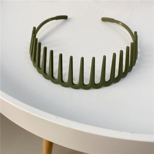 Detail of army green matte wavy headband with teeth for sports on a white table
