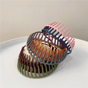 Detail showing various colors of matte bird nest hair clips in a stacked arrangement