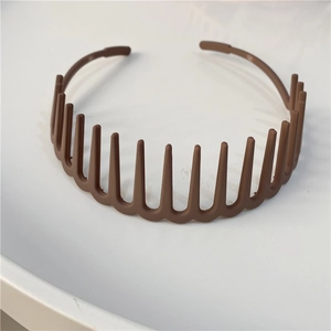 Close-up of brown plastic headband with teeth for secure grip and minimalist design