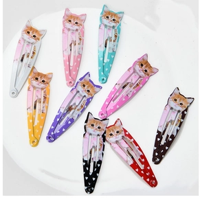 Flat lay showing set of nine colorful pet hair clips with orange cat and heart prints