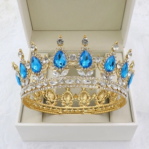 Detail of baroque gold bridal crown with blue teardrop crystals in a beige gift box
