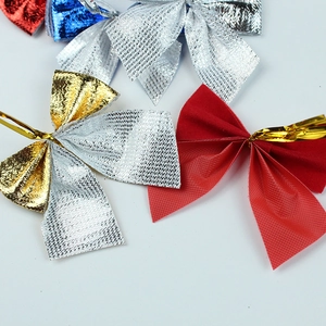 Detail of 5.5cm textured Christmas bows in multiple colors with gold wire ties for decor