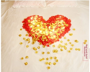 Romantic heart-shaped red and gold silk rose petals with warm white LED string lights