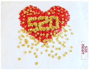 Red and gold faux rose petals forming a heart shape and 520 on a white textured background