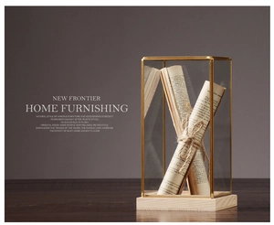 Detail of minimalist brass glass display case with a natural wooden base for decor