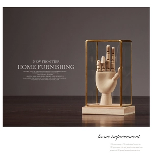 Detailed view of an adjustable wooden hand model inside a brass and glass display case