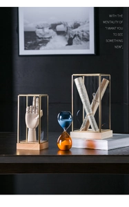 Detail of brass glass display box with contrast blue and orange sand timers