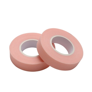 Two rolls of breathable pink medical tape for eyelash extensions on white background