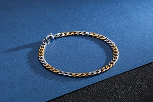Close-up of dual-tone gold and silver Cuban link bracelet with a lobster clasp