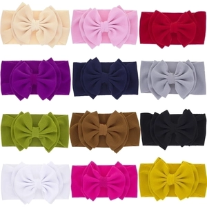 Flat lay of 12 colorful waffle fabric bow headbands for babies in a neat grid layout