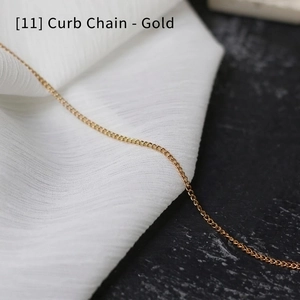 Close-up of golden stainless steel curb chain on elegant white and black texture