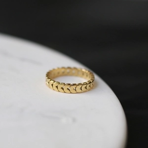 Macro view of gold wheat ear pattern ring with polished minimalist leaf design