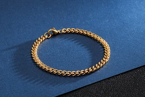Detailed view of a thick gold stainless steel curb chain bracelet with lobster clasp