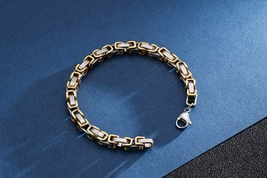 Detail view of two-tone gold and silver stainless steel king chain bracelet with lobster clasp