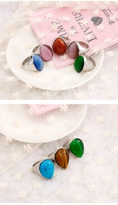 Detailed macro view of teardrop stone rings in various colors with metallic settings