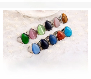 Detailed view of teardrop natural stone rings in various colors on steel band