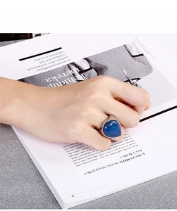 Detail shot of vintage stainless steel ring with pear-shaped turquoise stone on hand