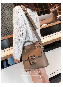 Detail of grey crossbody bag with gold square buckle and stylish wide shoulder strap