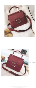 Detail view of burgundy matte leather crossbody bag featuring a large gold square buckle