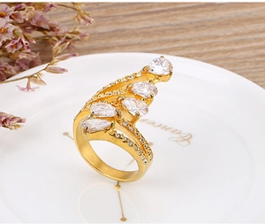 Detail van 18k vergulde ring met vijf peervormige zirkonia's op een wit bord gepresenteerd
