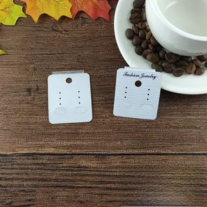 Macro view of white earring display cards with Fashion Jewelry text on wood surface
