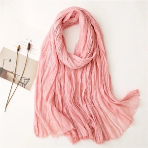 Light pink pleated long scarf for women with fringe details on a minimalist background