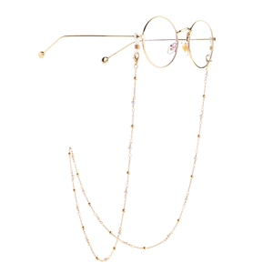 Golden round frame glasses with elegant pearl bead chain on a minimalist white background