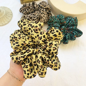 Three oversized leopard print scrunchies in yellow, brown and green chiffon fabric