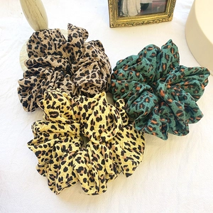 Three-piece set of oversized leopard print scrunchies in brown, yellow, and green