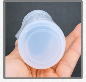 Close-up of translucent silicone measuring cup with white scale markings for DIY resin art