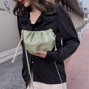 Detail of sage green ruched cloud bag showing soft leather texture and drawstring closure